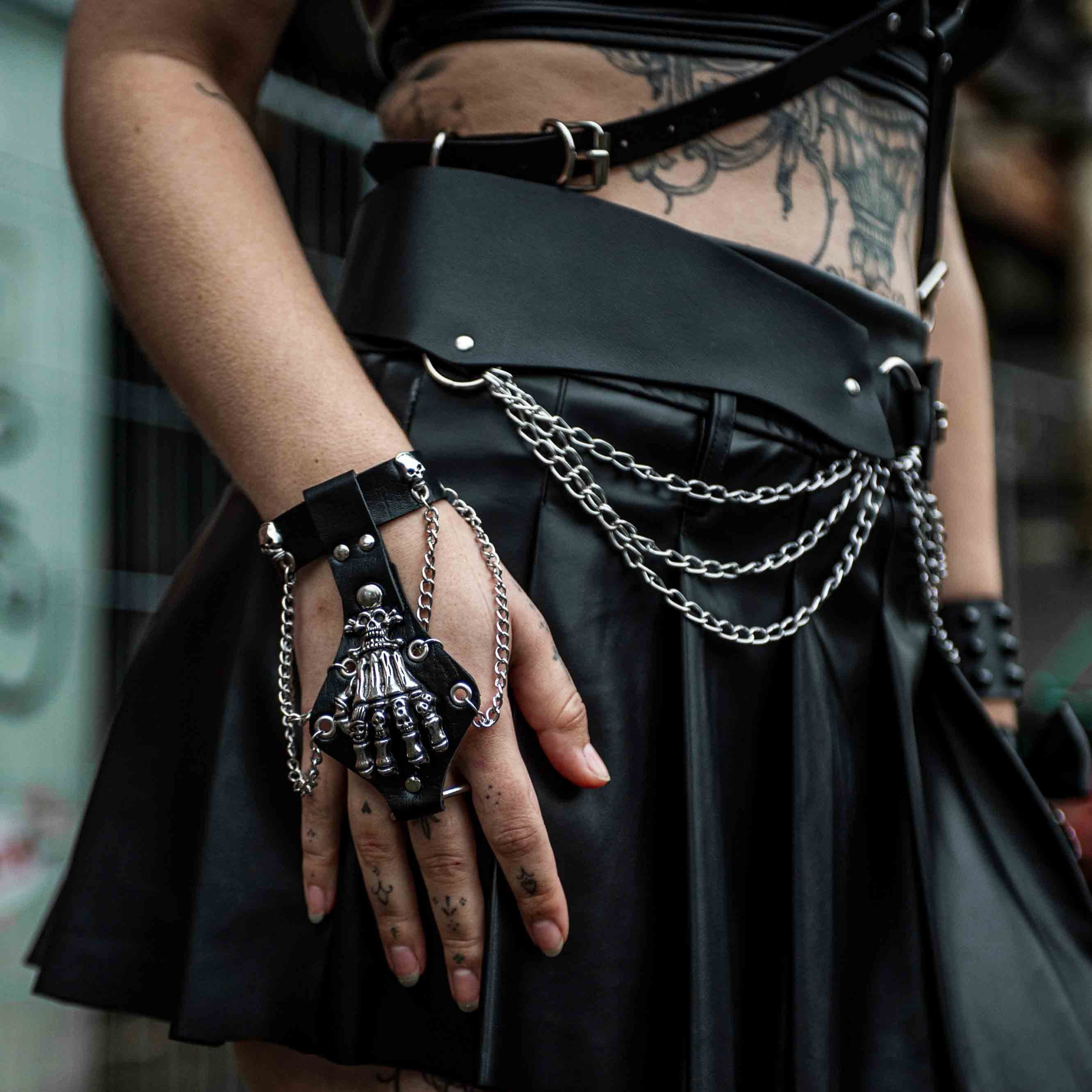 rave armband 'bone hand'. een leren armband met een skelethand bovenop en ijzeren kettingen.
