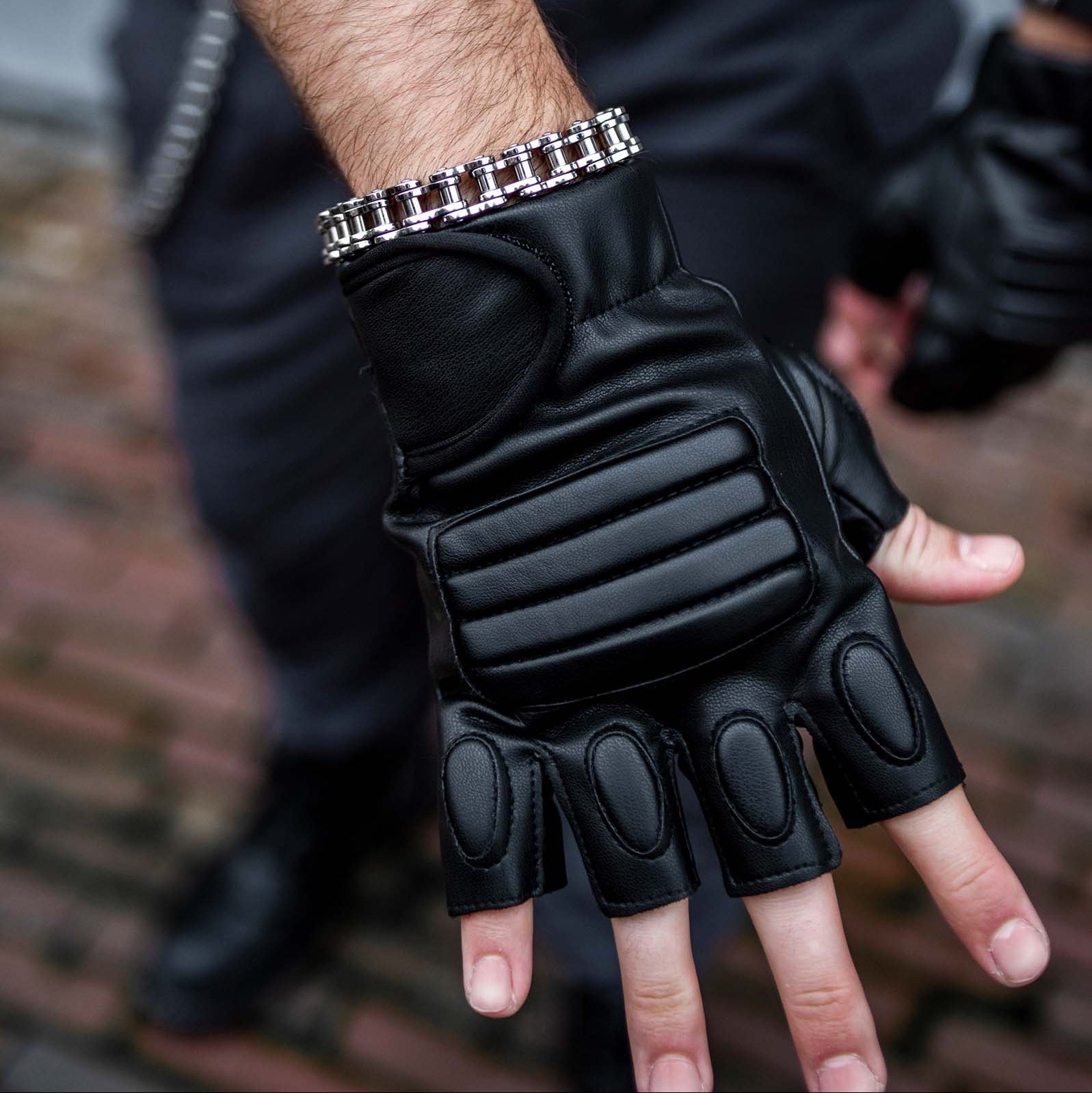 Model met rave armband 'biker'. RVS fietsketting model. Close up arm