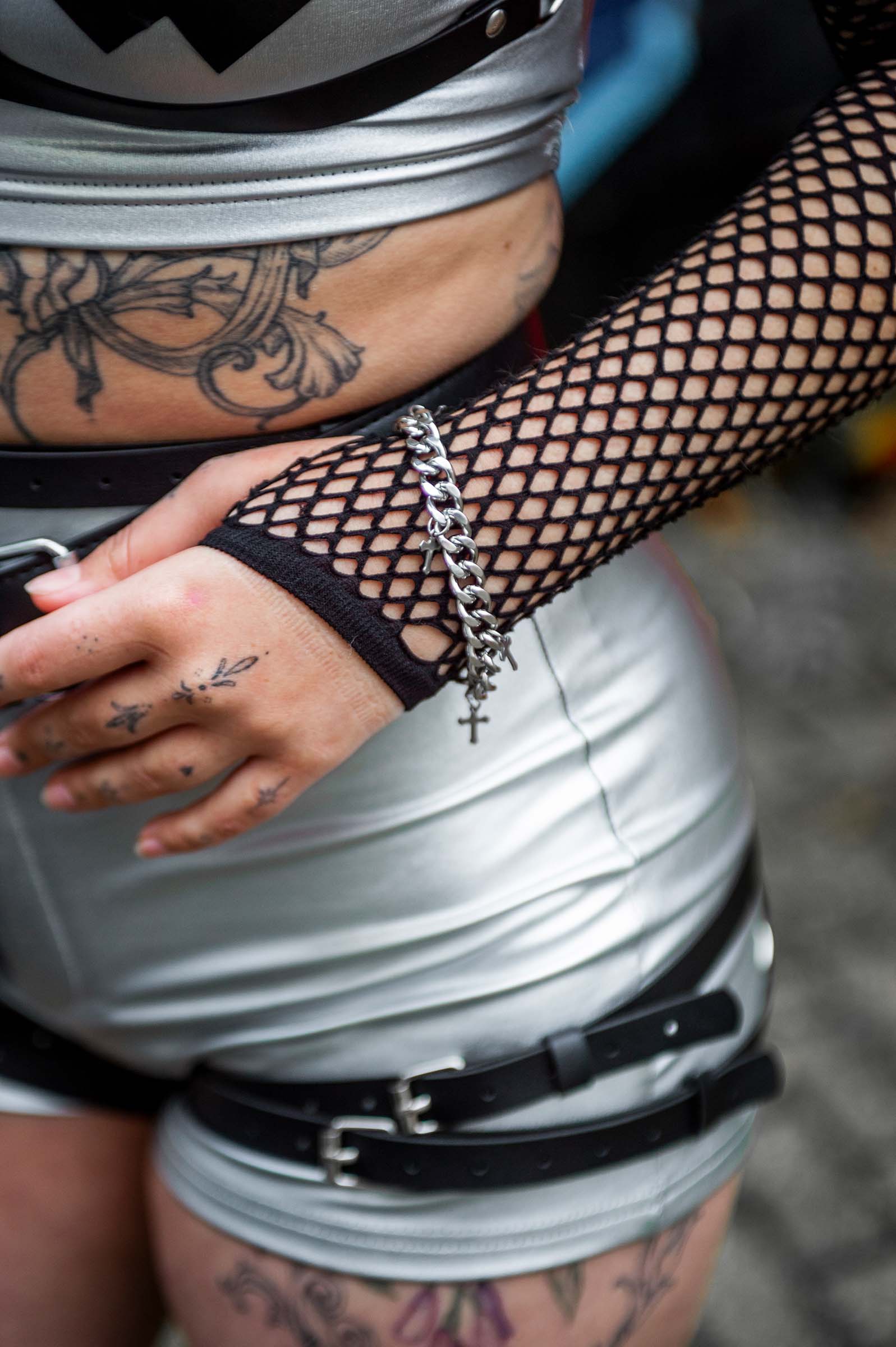 Model met van rave armband 'holy'. een zilveren armband met zilveren kruisjes. Close up arm