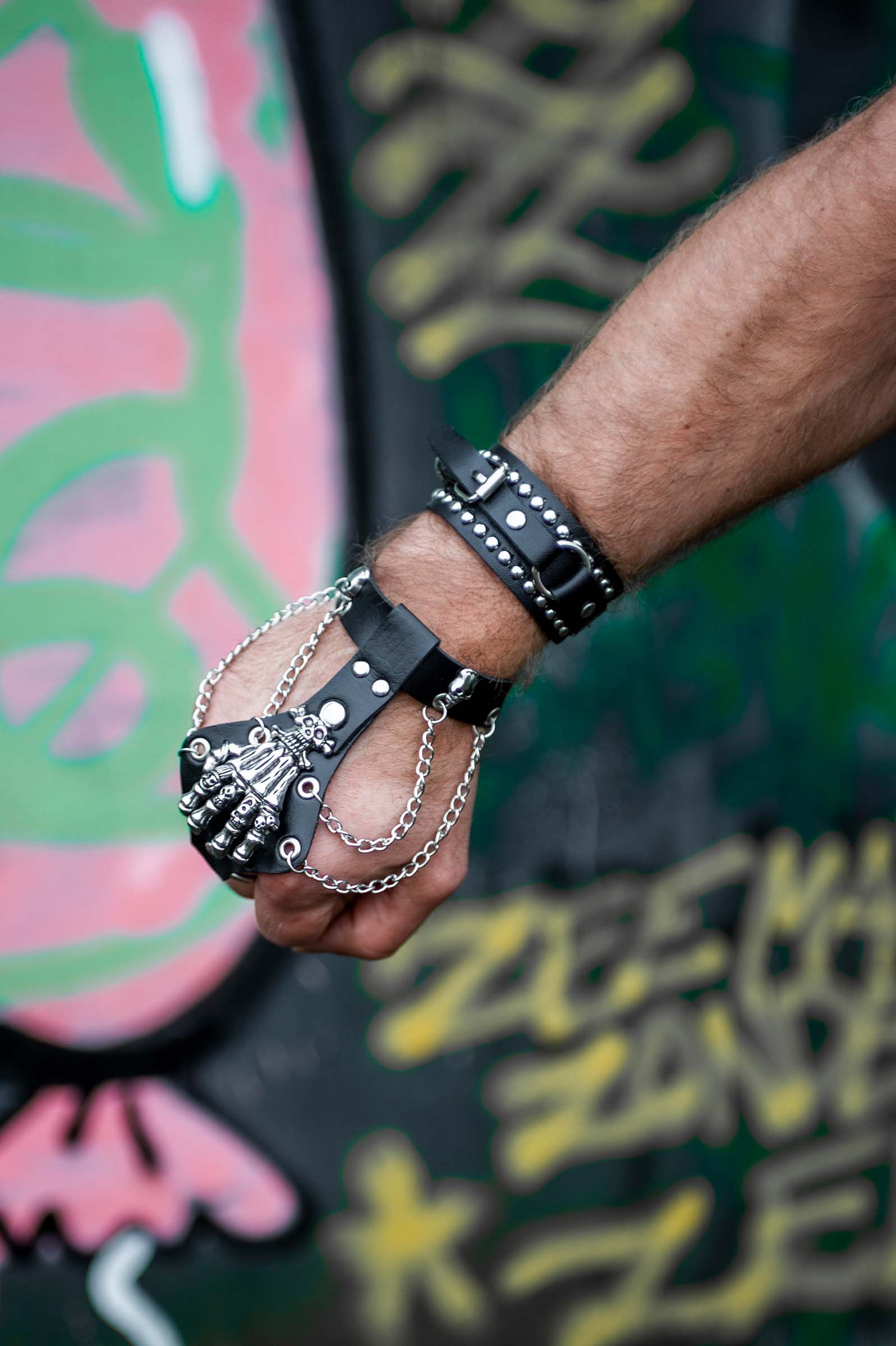 rave armband 'bone hand'. een leren armband met een skelethand bovenop en ijzeren kettingen.
