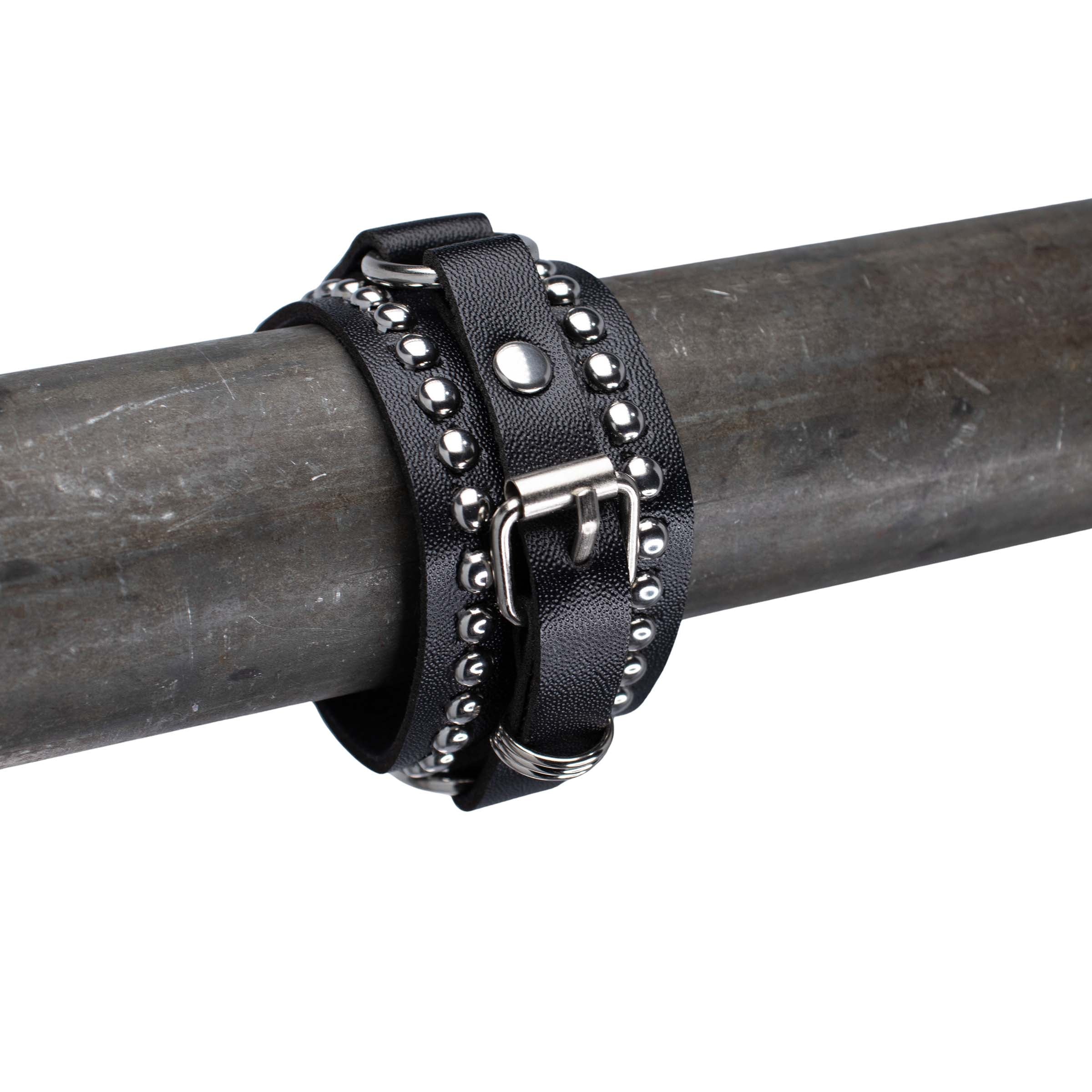 Close up voorzijde van leren rave armband met zilveren studs.