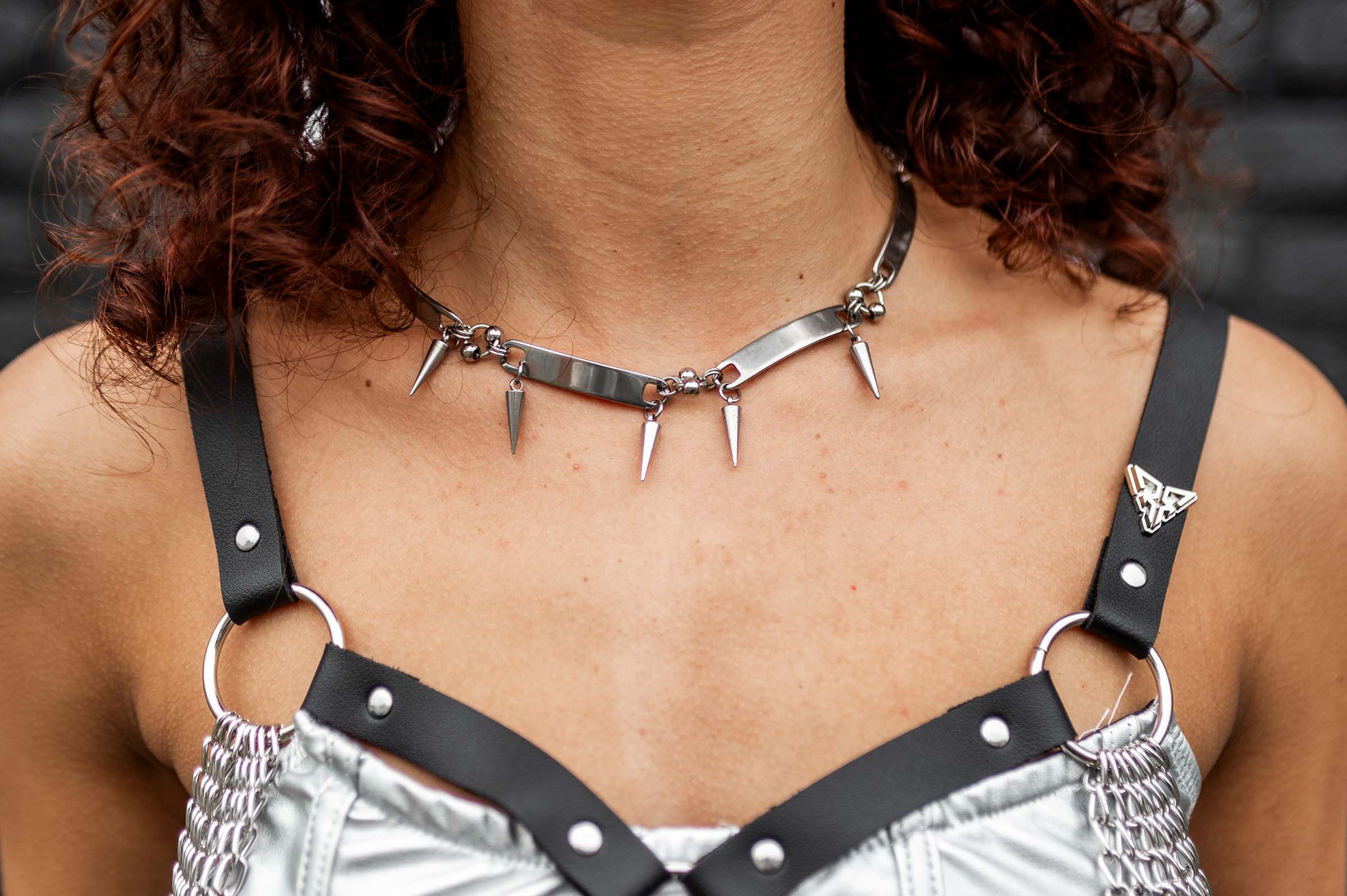 Model draagt de 'Iron Choker' rave ketting van RARE RAVERS, een zilveren ketting met rauwe, industriële uitstraling. Mooi accessoire voor techno festivals en underground raves.