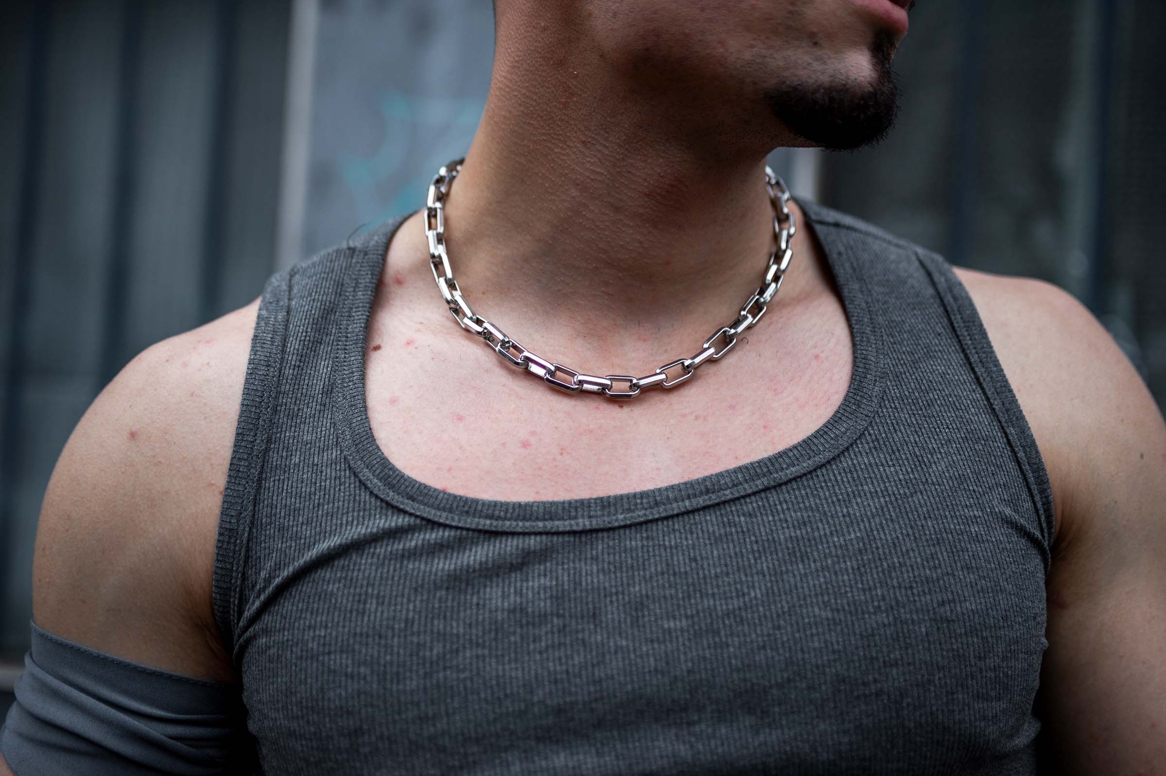 Model draagt de 'RRChain' rave ketting van RARE RAVERS, een zilveren ketting met robuuste metalen schakels, perfect voor een rauwe, industriële look op techno festivals en raves.