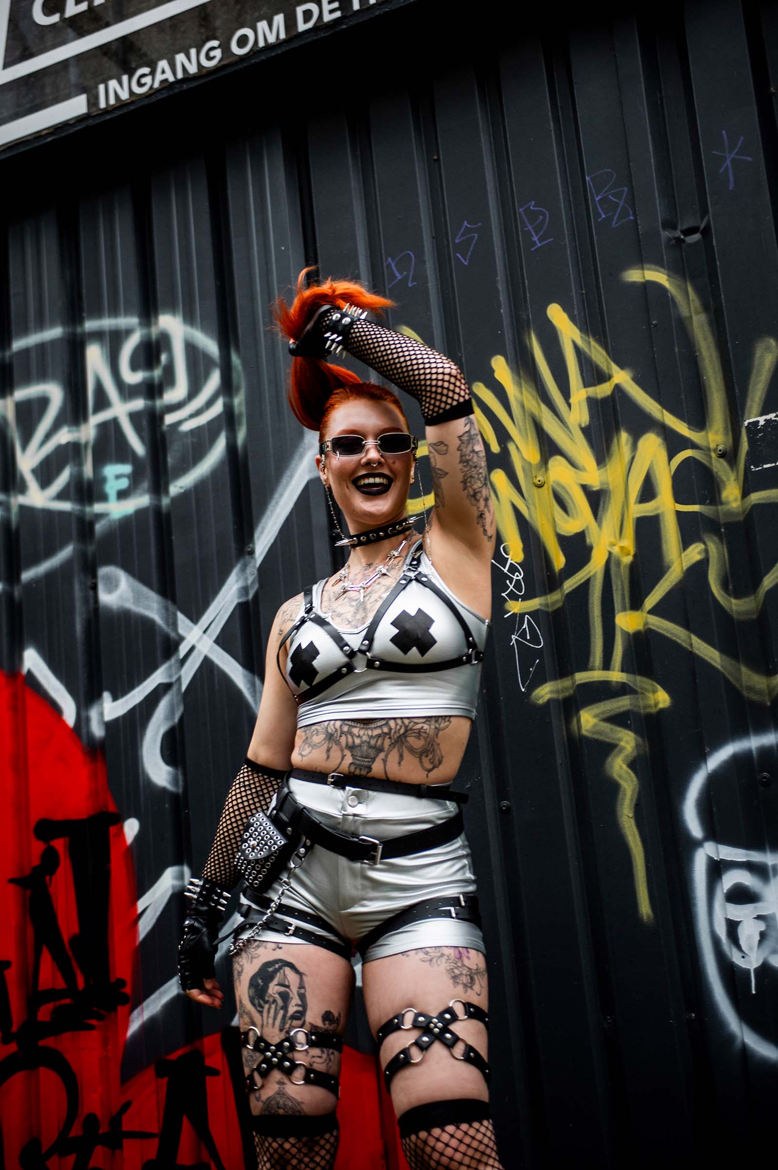 Vrouwelijk model op festivalterrein die punk raver belt draagt 