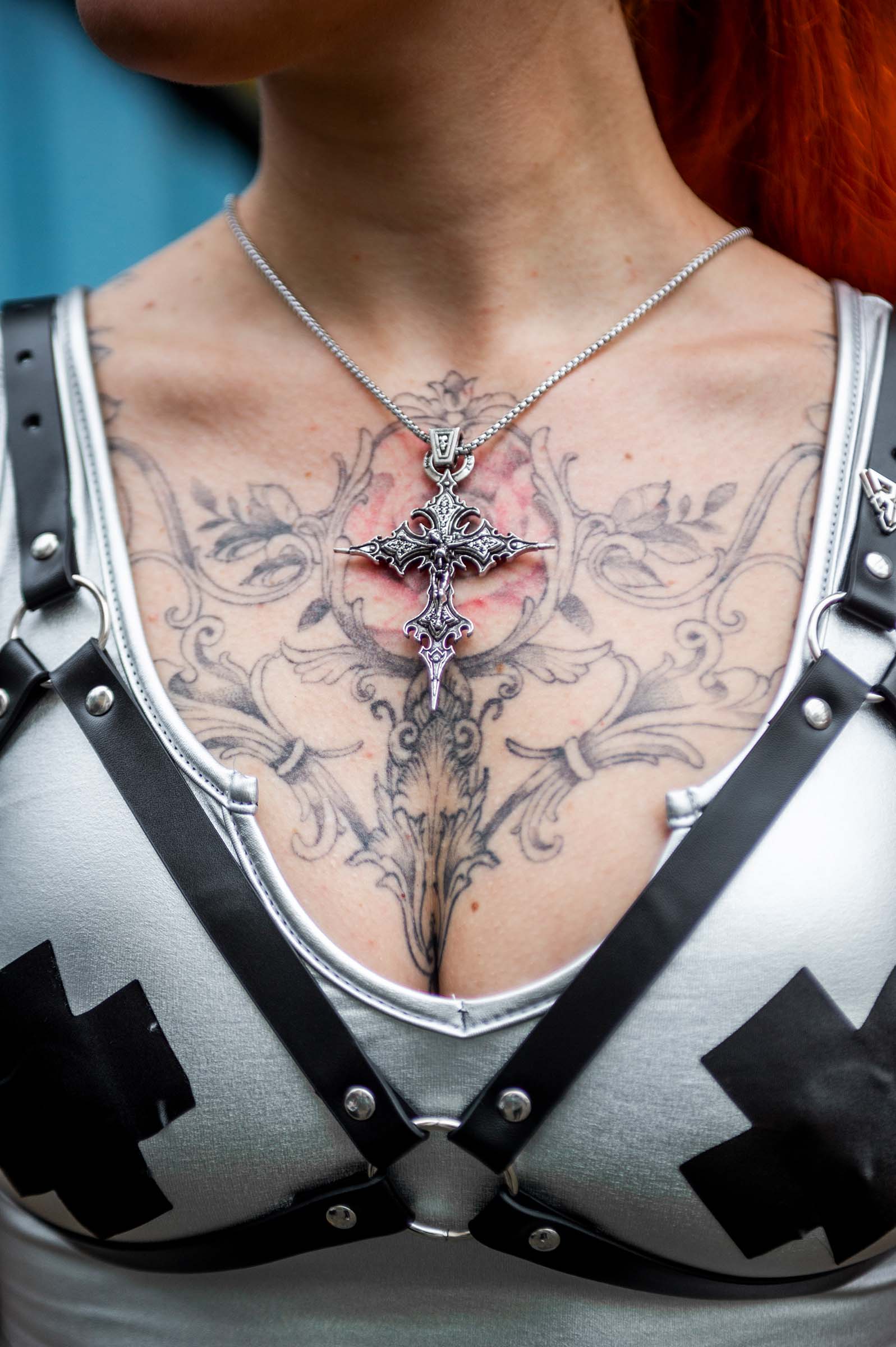 Model met  'Dark Cross' rave ketting van RARE RAVERS, een zilveren ketting met een groot kruis van 8,5 cm, perfect voor een unieke en opvallende rave- of techno-look.