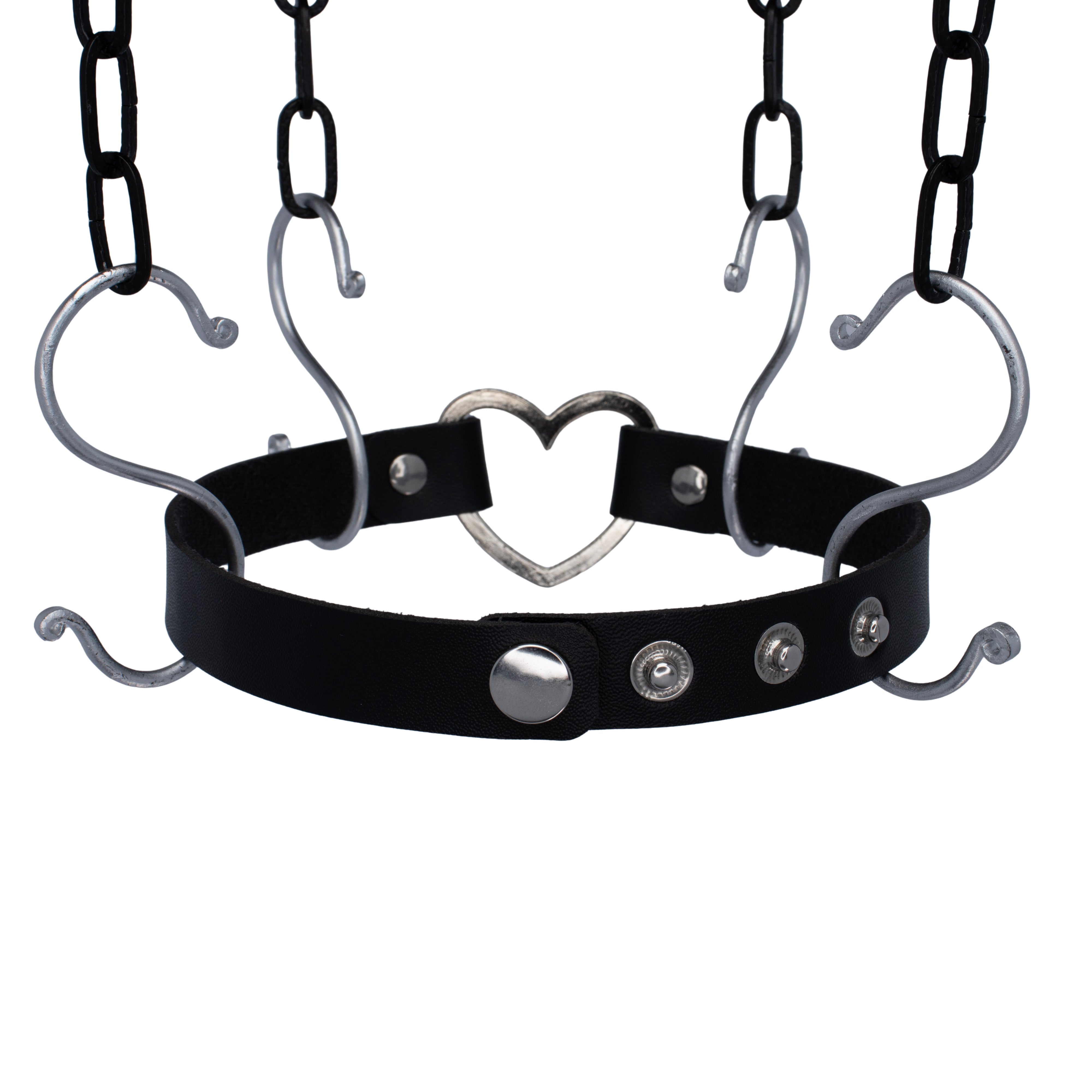 Zwarte PU-leren choker met zilveren hartdetail, verstelbaar met druksluiting. 51 cm lang en 2,5 cm breed, perfect voor unisex rave-stijlen en techno feesten.

Achterkant