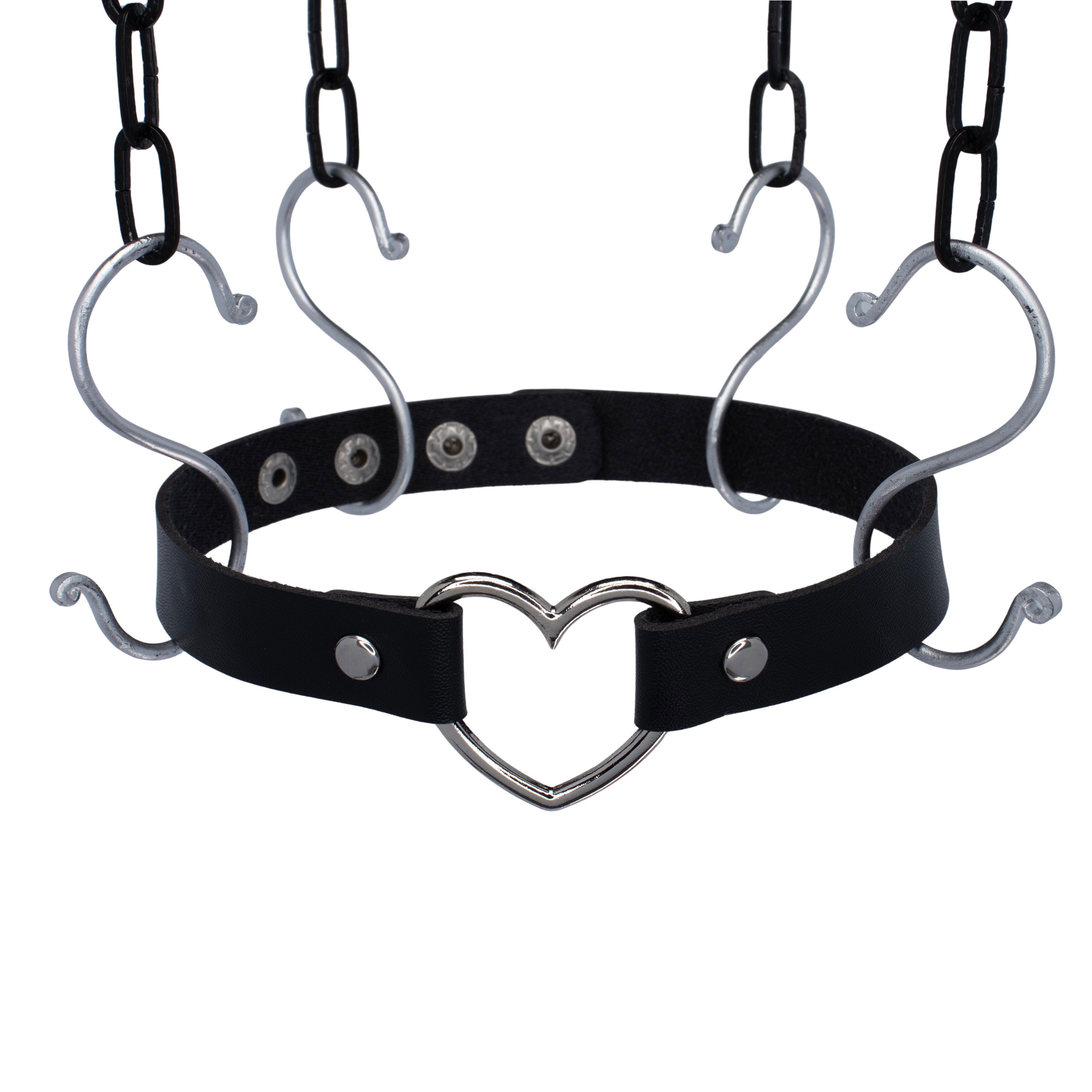 Zwarte PU-leren choker met zilveren hartdetail, verstelbaar met druksluiting. 51 cm lang en 2,5 cm breed, perfect voor unisex rave-stijlen en techno feesten.

Schuin van boven